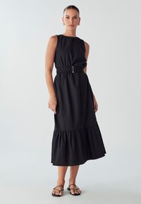 Black midi dress with a gathered neckline, elastic waist with a silver buckle, and a flared hemline. Natural fabric texture. Minimalist design.
