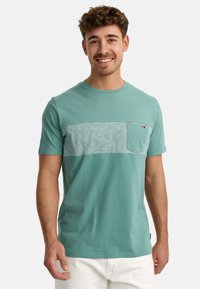 Turkist kortærmet t-shirt med en struktureret grå vandret stribe og lomme på brystet. Blødt materiale med rund hals.