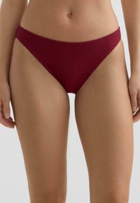 Bordo bikini spodnji del iz teksturirane tkanine z diamantnim vzorcem, z visoko rezano hlačko in zmernim pasom.