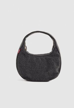 Grau farbene Stoffhandtasche mit runder Form, kurzem Henkel und einem kontrastierenden roten Logoetikett. Glatte Textur, schlichtes Design und Reißverschlussverschluss.