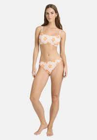 Bikini-set met oranje bloemenpatronen op een witte geruite achtergrond. De top heeft een gestructureerd ontwerp en verstelbare schouderbandjes.
