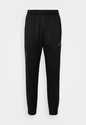 Pantaloni sportivi neri con una vita regolabile attraverso un cordino, design attillato e discreto logo verde sul lato sinistro. Tessuto morbido e gambe affusolate.