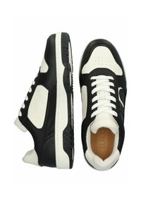 Čierno-biele tenisky s koženými a syntetickými materiálmi, textúrovaným povrchom, okrúlym prstom a bielymi šnúrkami s polstrovaným interiérom.