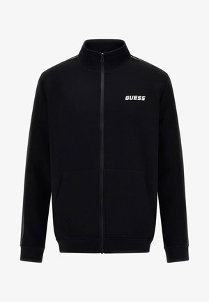 Schwarze Zip-Up-Jacke aus weichem Material mit zwei Fronttaschen, einem Stehkragen und einem weißen "GUESS"-Logo auf der Brust.