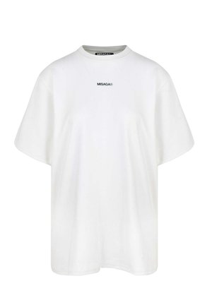 Biała, oversize'owa koszulka z bawełny z krótkim rękawem i okrągłym dekoltem. Posiada małe czarne logo "MISAGA®" z przodu.