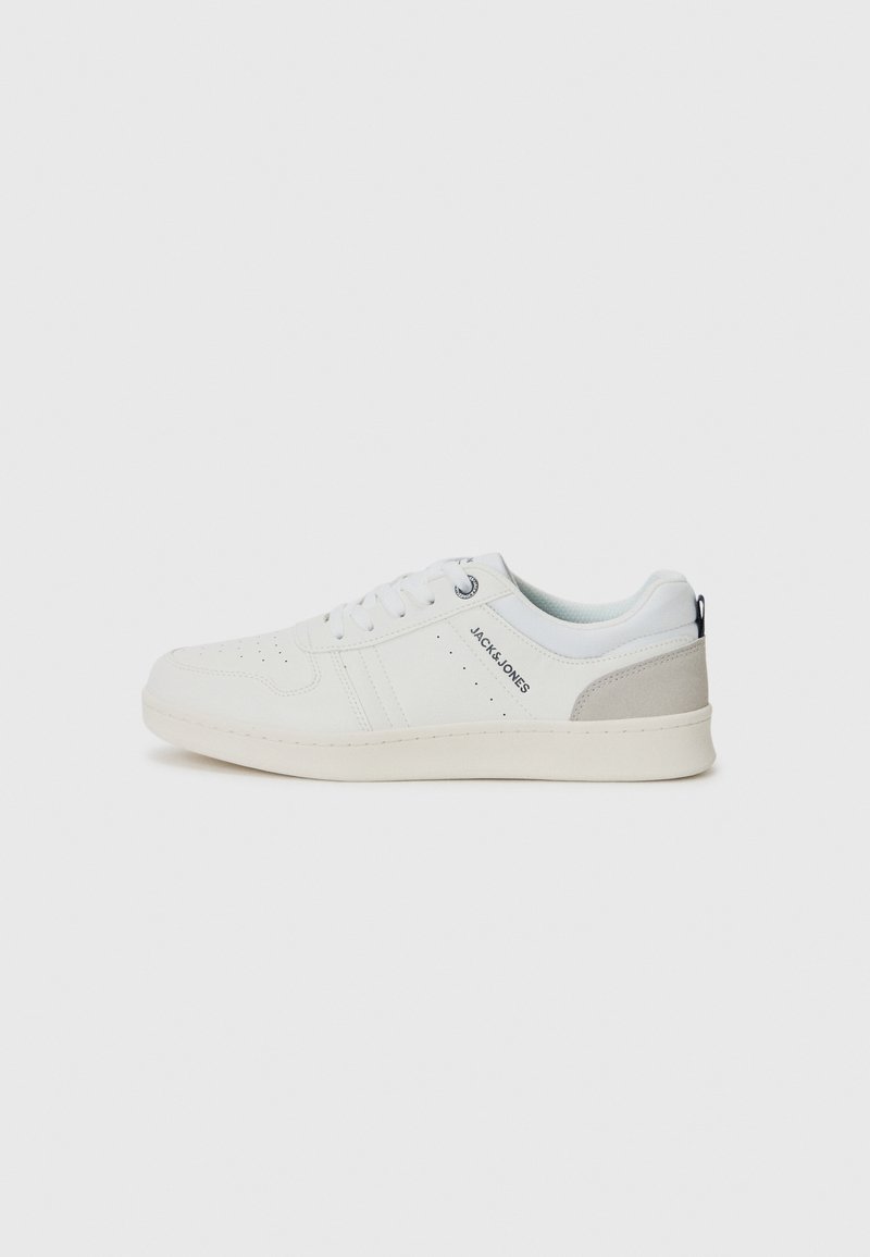 Zapatillas blancas informales con un diseño perforado y acentos en gris claro, con cordones y branding en el lateral, exhibidas sobre un fondo liso.