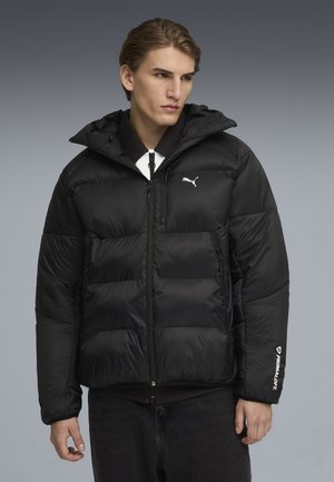 Schwarze Pufferjacke mit Kapuze, Reißverschluss vorne und elastischen Bündchen. Verfügt über ein weißes Logo auf der Brust und dem Ärmel, gefertigt aus glänzendem Material.