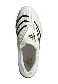 Baltie Adidas sporta apavi ar melnām svītrām, teksturētiem rakstiem virspusē, un zelta Adidas logo uz mēles un iekšējā zoles, skatīti no augšas.