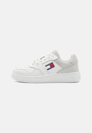 Białe sneakersy z mieszanką gładkich i zamszowych tekstur, z wielokolorową naszywką z logo po boku i gumową podeszwą.