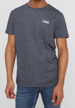 Grå melange kortærmet t-shirt af bomuld med rund hals og hvidt logo på venstre bryst. Stylet med blå jeans.