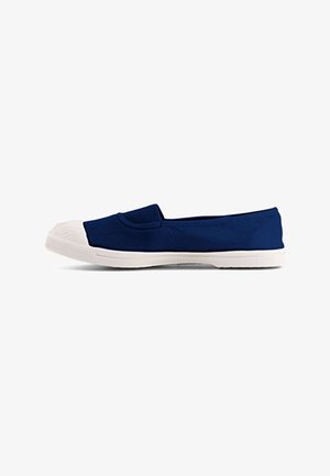 Chaussure en toile bleu marine à enfiler avec embout en caoutchouc blanc et semelle blanche texturée, vue de côté sur fond blanc.