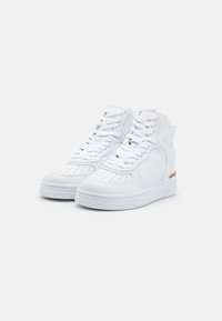 Białe sneakersy typu high-top z teksturowanej skóry z perforacjami, płaskimi białymi sznurowadłami i małym drewnianym akcentem na pięcie.