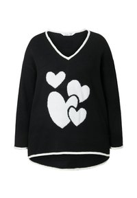 Černý svetr s výstřihem do V, zdobený bílými vzory srdcí. Měkká textura, dlouhé rukávy a kontrastní bílý lem na okrajích.