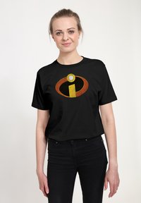 Černé tričko s krátkým rukávem s velkým, barevným logem "Incredibles" v oranžové, žluté a bílé barvě, umístěným uprostřed na přední straně.