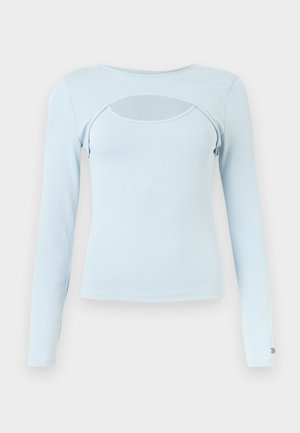 Lichtblauw topje met lange mouwen, een ronde halslijn en een horizontale uitsnijding over het borstgebied.