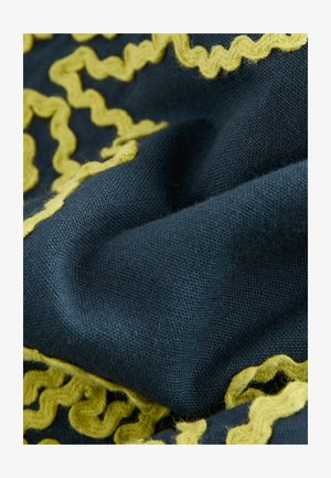 Jūras spēku audums ar teksturētu austu rakstu, kam pa malām ir viļņota dzeltena apdare. Materiāls izskatās mīksts un nedaudz pūkains.