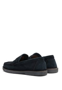 Loaferi din suede de culoare albastru închis, cu o textură moale, vârf rotunjit și cusături minime. Au un profil jos și o talpă din cauciuc pentru aderență.