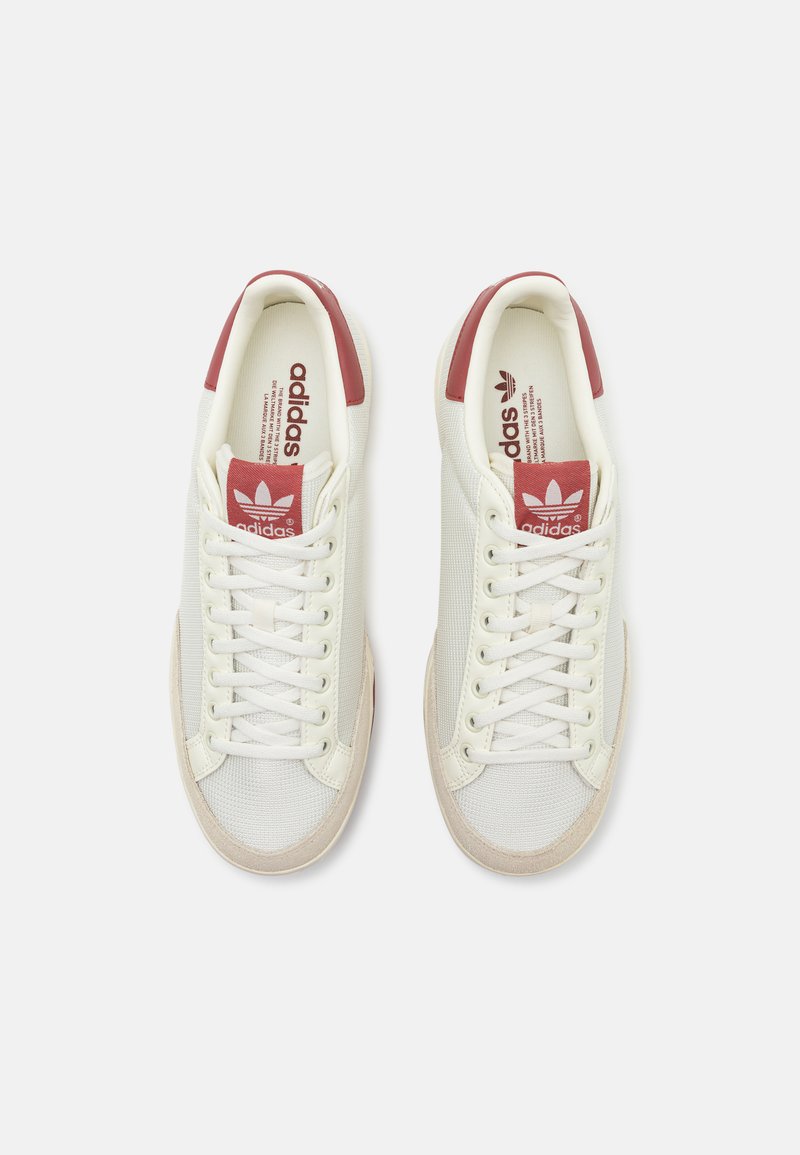 Baskets en toile blanches avec des accents rouges sur le talon et le logo. Présentent une surface texturée, un bout arrondi et des lacets plats.