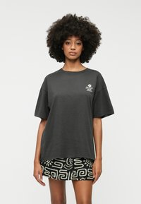 Must have mustelakujuline must t-särk, mis on valmistatud puuvillast, ringkraega ja lühikeste varrukatega. Vasakul rinnal on märkimisväärne valge logo.