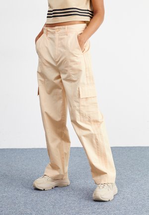 Pantalon cargo pêche avec une coupe décontractée, doté de poches latérales, d'une texture subtile et de rayures verticales contrastées sur les côtés.
