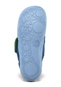 Blauer Gummisohlenbereich eines Kinderschuhs mit kreisförmigen Profilmustern und einem lächelnden Gesichtsmuster in der Nähe des Fußgewölbes.
