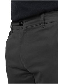 Pantaloni in cotone grigi con una texture liscia, caratterizzati da una chiusura con bottone nero e una vestibilità standard. La vista laterale mostra i dettagli delle cuciture e le tasche.