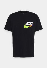 Czarna koszulka Nike z krótkim rękawem z kieszonką z przodu, ozdobiona kolorowym, zniekształconym logo "NIKE Just Do It" w białym, zielonym, pomarańczowym i fioletowym kolorze.