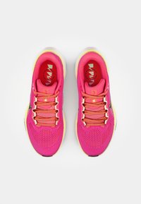 Pink mesh athletic shoes with a breathable upper, orange laces, and a light yellow sole. Features a logo on the insole and heel.