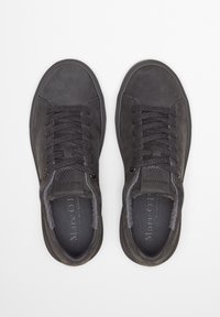 Czarne skórzane trampki o zaokrąglonych czubkach, o fakturowanej powierzchni, z płaskimi sznurowadłami i wyściełanymi kołnierzami. Logo widoczne na wkładkach i bokach.