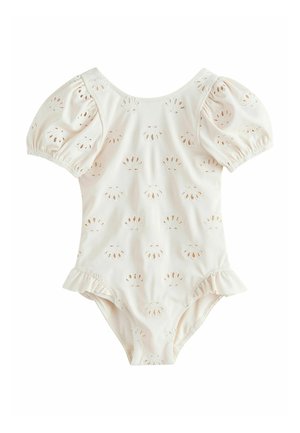 Baby-Strampler in Cremeton mit Puffärmeln, Lochstickerei-Mustern und Rüschensaum an den Beinen.