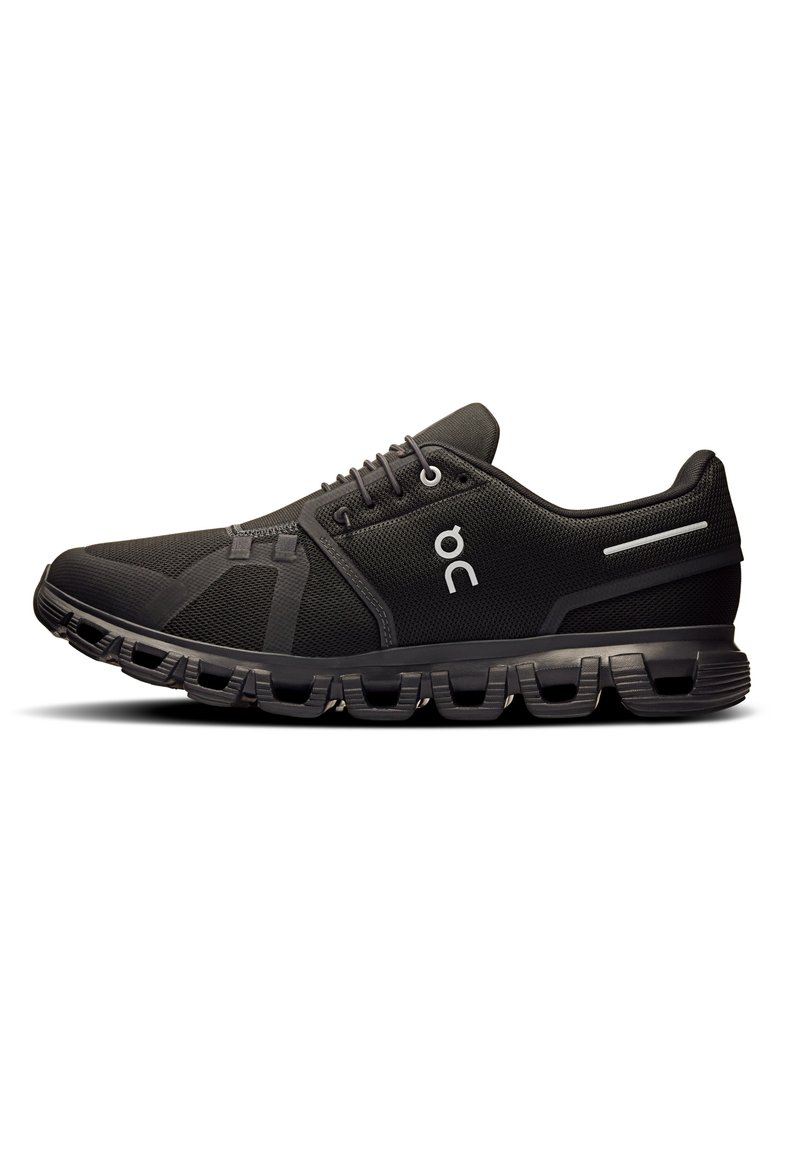Schwarze Sportschuhe mit einem strukturierten Mesh-Obermaterial, das eine aerodynamische Form, eine Gummisohle mit segmentierter Dämpfung und silberne Akzente aufweist.