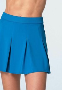 Una salopette plissettata di un blu brillante con un'ampia vita elastica e una texture liscia, progettata per l'abbigliamento sportivo.