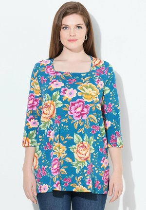 Blumen-Tunika mit quadratischem Ausschnitt, 3/4-Ärmeln und einem blauen Hintergrund mit großen rosa und gelben Blumen sowie grünen Blättern.