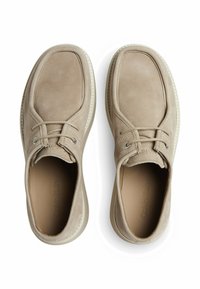 Scarpe in suede beige con punta rotonda, design strutturato e suola in gomma bianca a contrasto. Presentano lacci e logo sulla soletta.