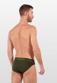 Groene katoen onderbroek met een logoband aan de taille, met een snug fit en een gladde textuur, van achteren weergegeven op een mannelijke model.