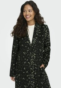 Cappotto a stampa leopardata nera e verde con taglio aderente, bottoni a un petto e tasche laterali, caratterizzato da revers e una superficie texturizzata.