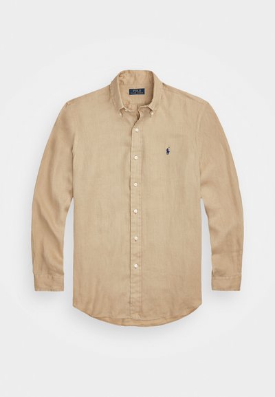 Camicia beige a maniche lunghe realizzata in tessuto leggero, con colletto a punta, pattina anteriore e piccolo logo blu sul petto.