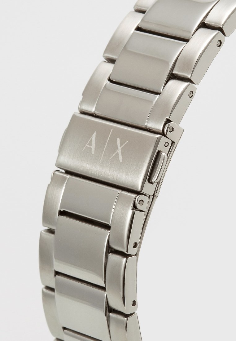 Bracciale per orologio in acciaio inox argento con design a maglie, dotato di un logo A/X inciso su un clasp lucido. Texture liscia e riflettente.