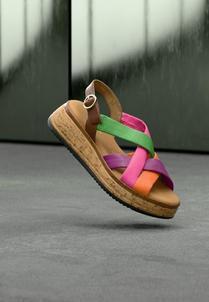 Kleurrijke sandaal met een bruine band en kruisvormige, veelkleurige banden in roze, groen, oranje en paars. Kurkwedgelaars met rubberen zool.