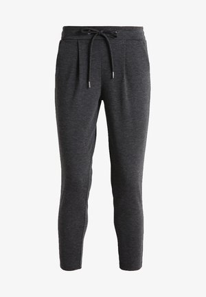 Pantaloni da tuta tapered grigio scuro con vita regolabile, frontale plissettato, texture morbida e design alla caviglia. Adatti per un abbigliamento casual.