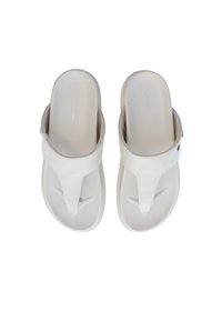 Ljust beige flip-flops med en slät, matt yta, som har en tåpostdesign och en dämpad sula för komfort. Minimal varumärkesdetalj inkluderad.