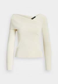 Krämfärgad off-shoulder topp med långa ärmar, som har en omlott-design och ett slätt, texturerat tyg. Lappen synlig vid halsringningen.