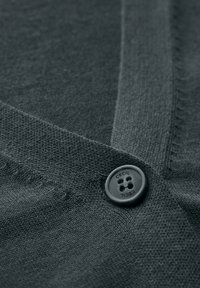 Cardigan tricoté gris foncé avec un col en V et un bouton rond noir portant l'inscription "CECIL" en relief. La texture semble lisse et uniforme.