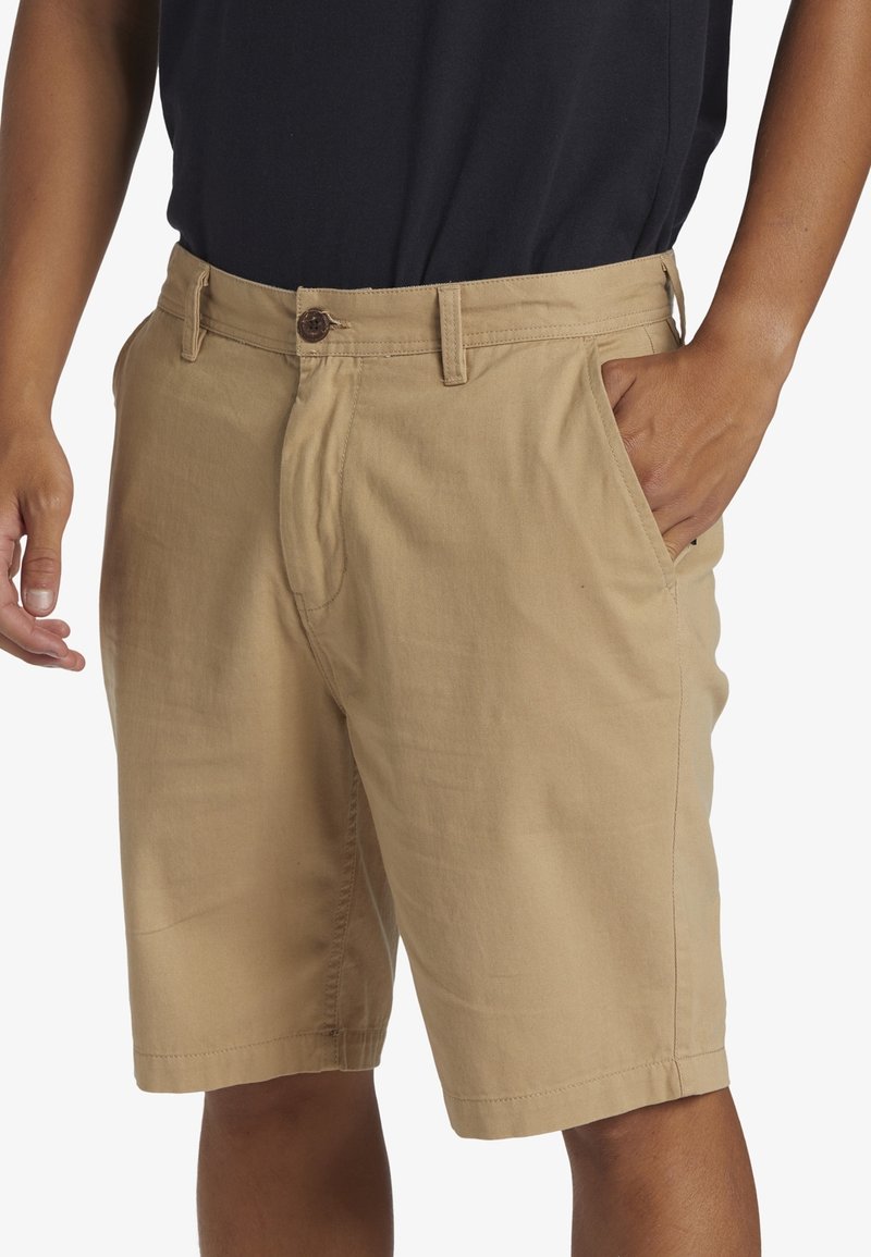 Kakifärgade shorts i lättviktig tyg, med knappstängning, sidofickor och rak passform för komfort och rörlighet.