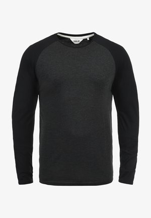 Svart langermet skjorte med rund hals. Har raglanermidd og en subtil heathered tekstur på kroppen.