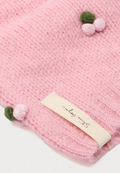 Απαλή ροζ πλεκτή ύφανση με μικρές πράσινες και ροζ πον πον διακοσμήσεις και μια μπεζ ετικέτα μ�ε καλλιγραφικό κείμενο.