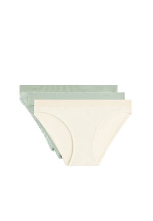 Trois sous-vêtements style bikini en tissu côtelé crème et deux nuances de vert sourd empilés sur un fond blanc.
