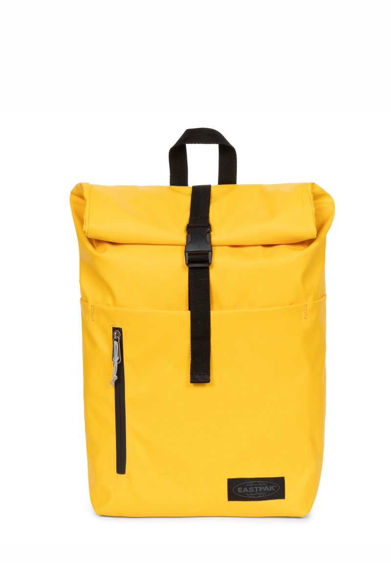 Gelbe Rolltop-Rucksack mit schwarzem Zubehör, verstellbaren Trägern, einer vorderen Reißverschlusstasche und einem Markenlabel an der Unterseite. Aus wasserdichtem Material.