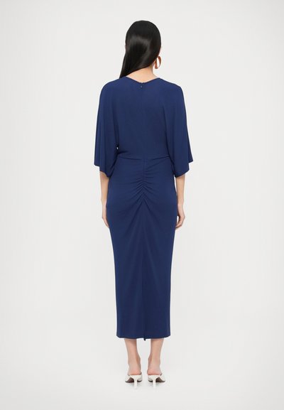 Μίντι φόρεμα σε ναυτικό μπλε με χαλαρή εφαρμογή, ραβδώσεις στην πλάτη, φαρδιά μανίκια και διακριτικό φερμουάρ στην πλάτη. Ομαλή υφή υφάσματος.