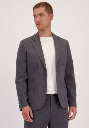 Grijze blazer met een notch lapel, twee knopen en een borstzak, gecombineerd met een witte crewneck t-shirt en bijpassende grijze broek.